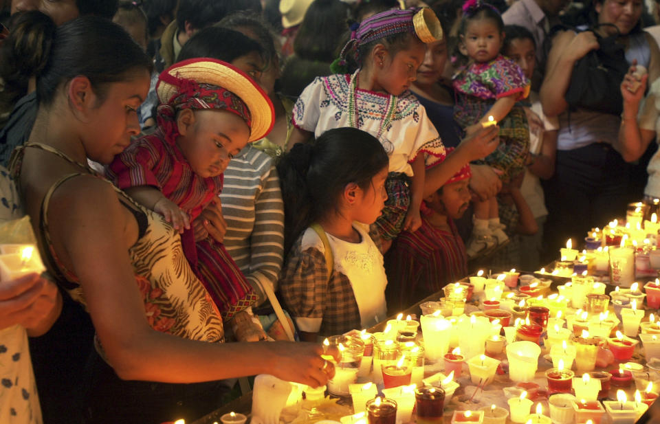 Faithful light candles while visiting the Virgin of Guadalupe's Sanctuary to celebrate her day in Guatemala City on Thursday, Dec. 12, 2002. On Friday, May 17, 2024, the Vatican will issue revised norms for discerning apparitions "and other supernatural phenomena," updating a set of guidelines first issued in 1978. (AP Photo/Jaime Puebla, File)