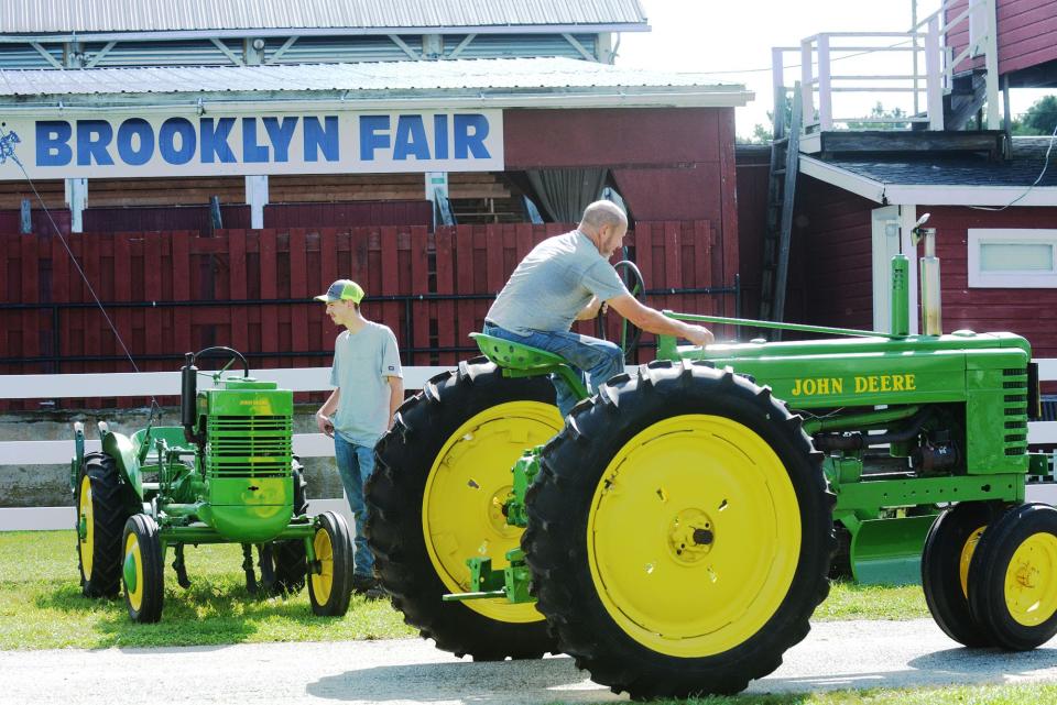 Albert Exley backs up his 1940 John Deere B tractor near his nephew Dale Eaton, both of Plainfield, Tuesday for the opening day of the Brooklyn Fair in this file photo.