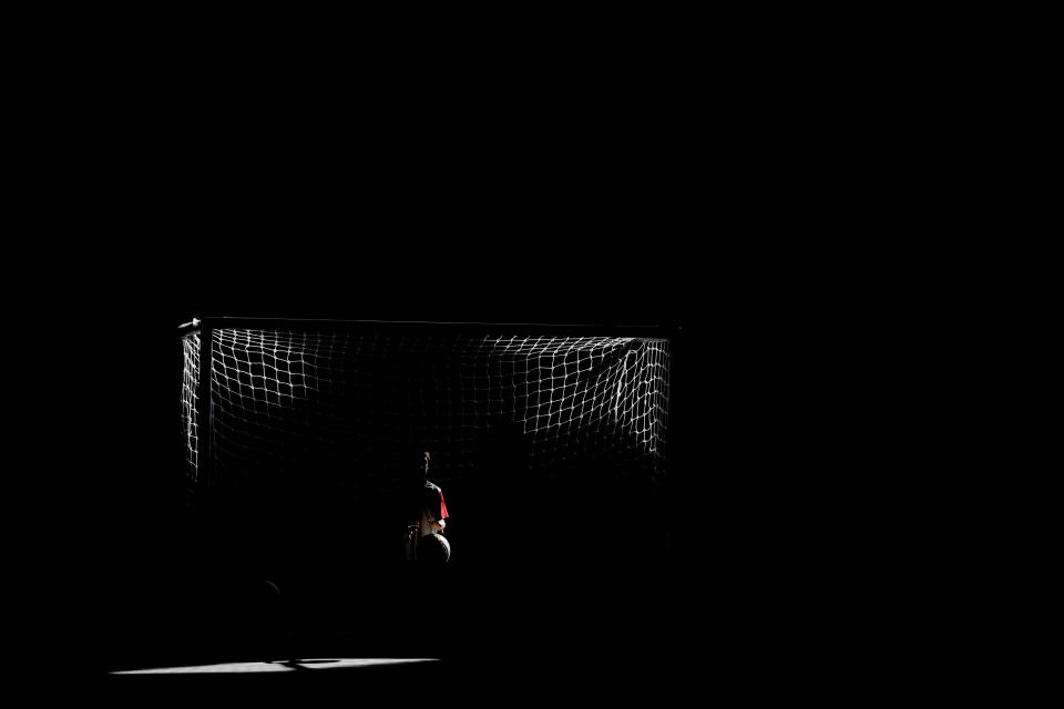 En esta foto del 18 de marzo de 2017, un jugador del Club Social Parque atrapa una pelota durante un juego en la academia juvenil de un vecindario de clase trabajadora en Buenos Aires, Argentina. “Siempre seguí pensando en Parque. En cada momento cuando necesitas resolver en la cancha, se te vienen imágenes de cuando eras chico, consejos que te daba el técnico”, dice César Lapaglia, exjugador profesional de Boca y del Tenerife de España, que jugó en el Parque cuando era niño. (AP Foto/Natacha Pisarenko)