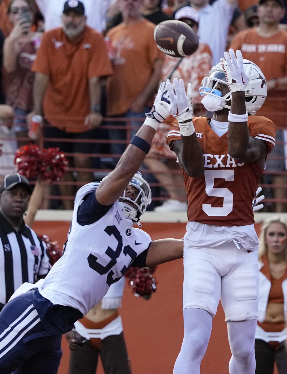 Texas wide receiver Adonai Mitchell (5) catches a pass in front of BYU safety Raider Damuni (33) for a touchdown during the first half of an NCAA college football game in Austin, Texas, Saturday, Oct. 28, 2023. | Eric Gay, Associated Press