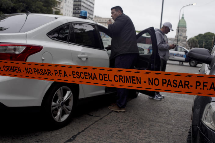 CORRECTS TO CHANGE FROM MOVING VEHICLE TO PARKED CAR - Police stand near the crime scene where Argentine lawmaker Hector Olivares was seriously injured and another man killed after they were shot at from a Parked car near the congressional building, in Buenos Aires, Argentina, Thursday, May 9, 2019. Officials say that Olivares was shot at around 7 a.m. local time. Olivares is a representative of La Rioja province in Argentina's lower house of Congress. He is being treated at a hospital in Buenos Aires. (AP Photo/Natacha Pisarenko)