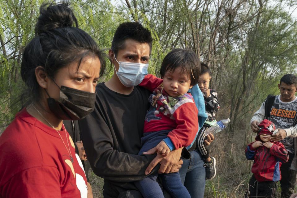 Honduran immigrants wait for the U.S. Border Patrol after crossing the Rio Grande River from Mexico into Mission, Texas, on March 24, 2021. <a href="https://www.gettyimages.com/detail/news-photo/immigrants-from-honduras-stand-and-wait-for-the-border-news-photo/1231998345?adppopup=true" rel="nofollow noopener" target="_blank" data-ylk="slk:Michael Robinson Chavez/The Washington Post via Getty Images;elm:context_link;itc:0;sec:content-canvas" class="link ">Michael Robinson Chavez/The Washington Post via Getty Images</a>