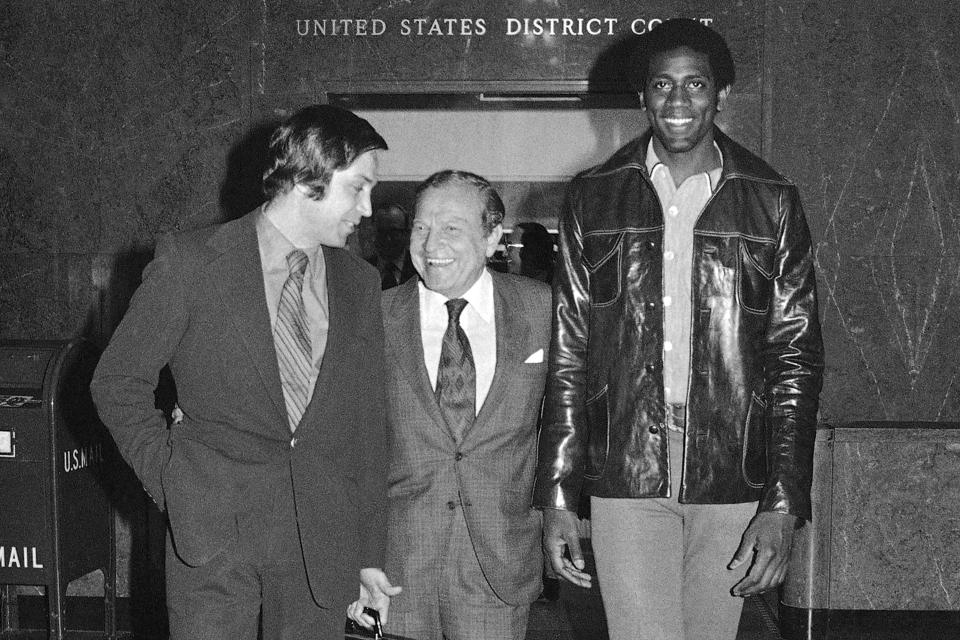 FILE - Basketball star Spencer Haywood leaves U.S. district court in Los Angeles with attorney Al Ross, left, and Seattle Supersonics president Sam Schulman, Jan. 8, 1971. With rare exceptions, the best high school basketball players for decades went on to play in college. Then came Spencer Haywood, whose fight with the NBA set the stage for the one-and-done era in college hoops. (AP Photo/Wally Fong, File)
