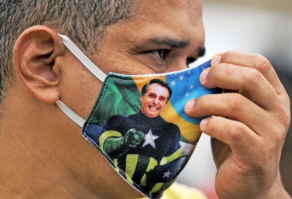 A supporter of President Jair Bolsonaro wears a face mask with Bolsonaro's image during a demonstration at Copacabana beach in Rio de Janeiro, Brazil, on June 7, 2020.