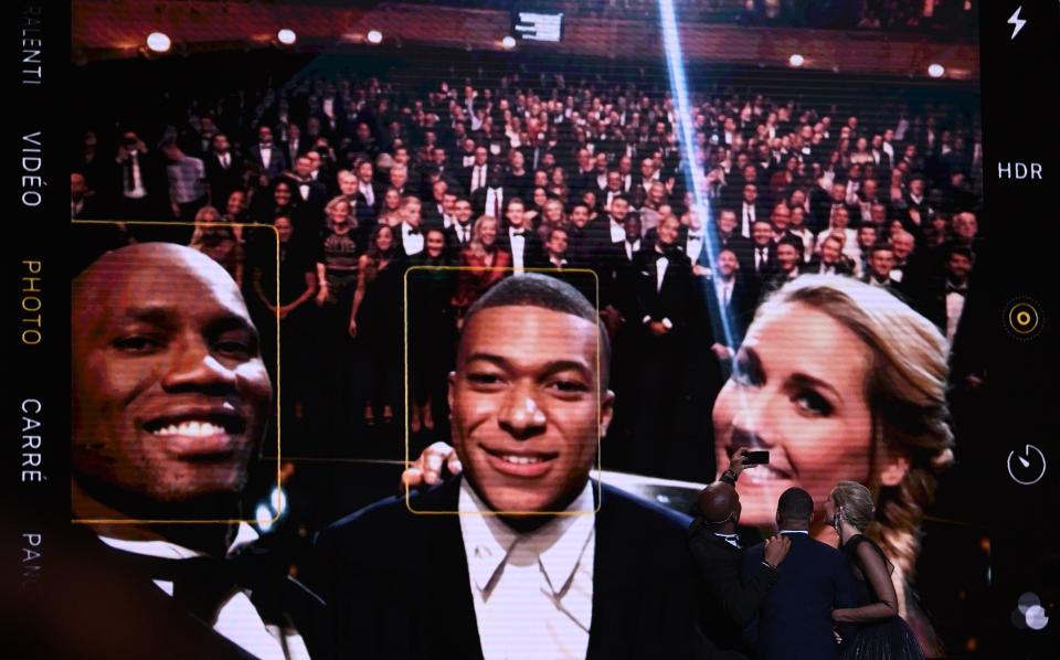 Didier Drogba (left) took a selfie with Kylian Mbappe (center) that was 10 years in the making. (Photo by FRANCK FIFE / AFP) (Photo by FRANCK FIFE/AFP via Getty Images)