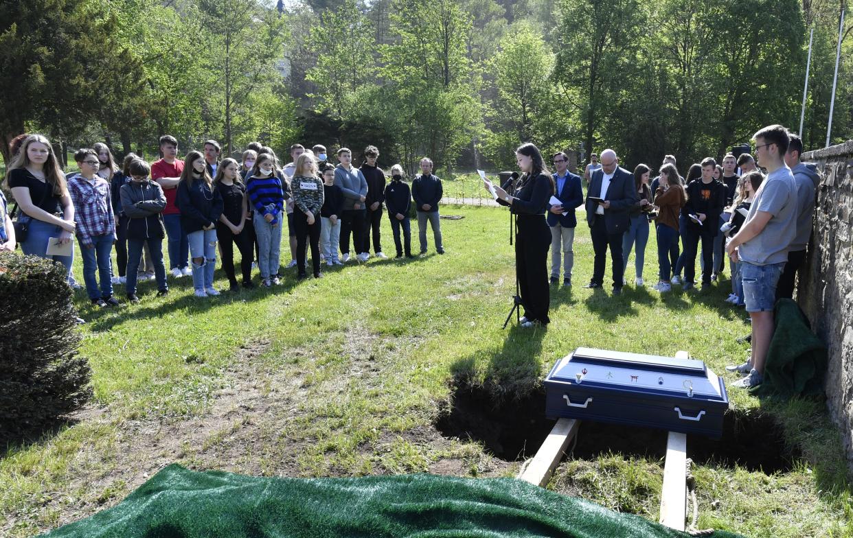 Pupils of the Johannes-Sturmius-Gymnasium say goodbye to the coffin with the bones of a school skeleton at the cemetery, where they are being buried, in Schleiden, Germany, May 11, 2022.