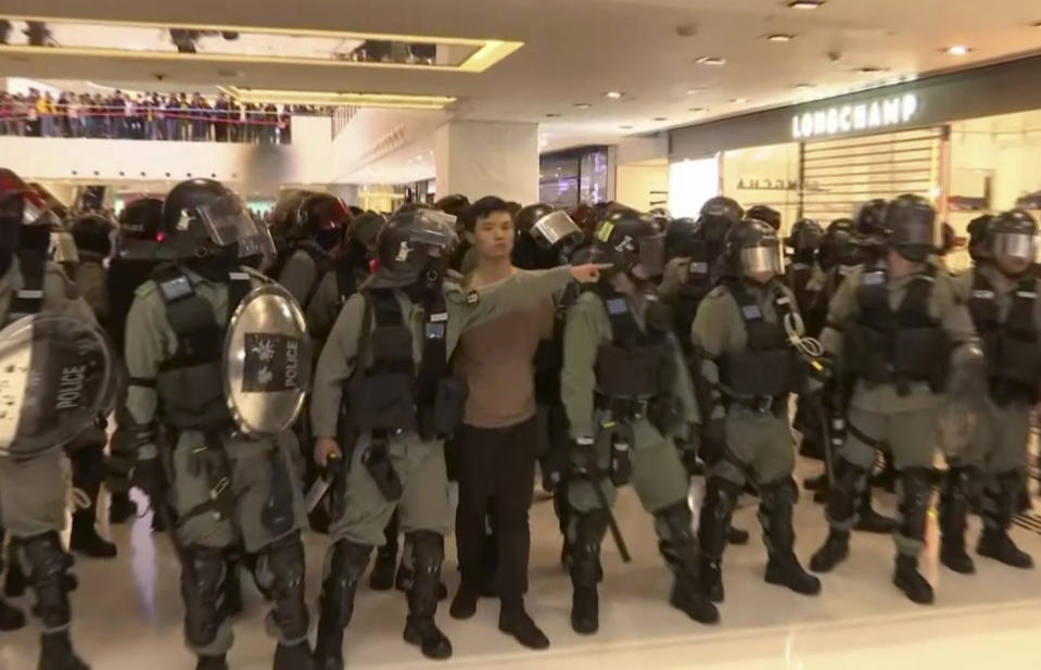 In this image made from video, a protester is arrested by police at a shopping mall in Sha Tin district in Hong Kong, with shoppers watch from balconies above, Sunday, Dec. 15, 2019. The rally, which had a Christmas shopping theme, was the latest in a series of demonstrations, which have beset Hong Kong for more than six months.(AP Photo)