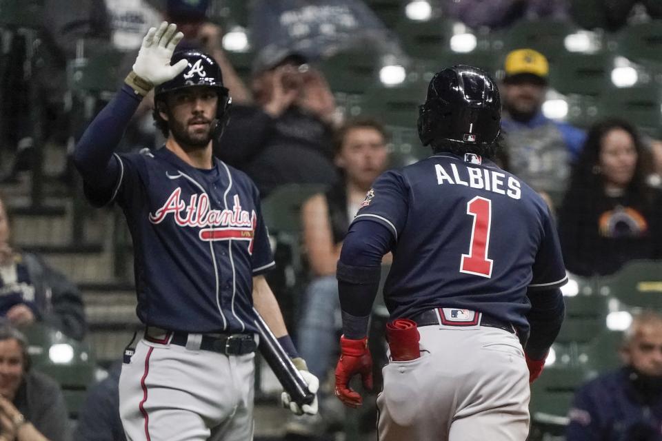 Atlanta Braves' Ozzie Albies is congratulated by Dansby Swanson after hitting a home run during the fifth inning of a baseball game against the Milwaukee Brewers Friday, May 14, 2021, in Milwaukee. (AP Photo/Morry Gash)