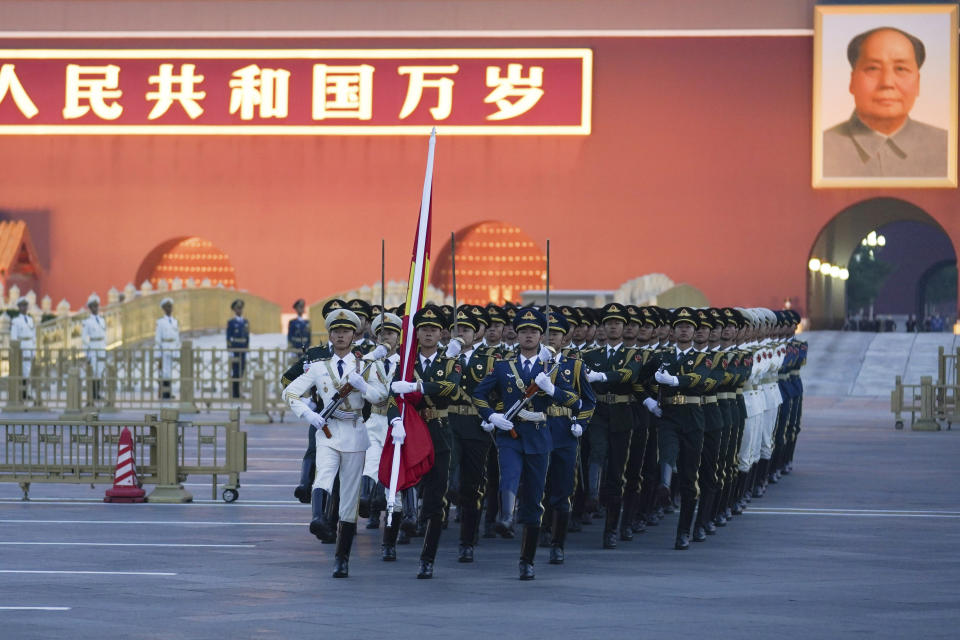 In this photo released by Xinhua News Agency, a Chinese honor guard march to a flag raising ceremony to mark the 73rd anniversary of the founding of the People's Republic of China held at the Tiananmen Square in Beijing on Saturday, Oct. 1, 2022. (Ju Huanzong/Xinhua via AP)