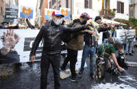 People spill beer on the ground during a protest against the government restriction measures to curb the spread of COVID-19, in Rome, Saturday, Oct. 24, 2020. Italian Premier Giuseppe Conte, who imposed severe-stay-at-home limits on citizens early on, then gradually eased travel and other restrictions, has been leaving it up to regional governors in this current surge of infections to order restrictions such as overnight curfews, including in places like Rome, Milan and Naples. (Mauro Scrobogna/LaPresse via AP)