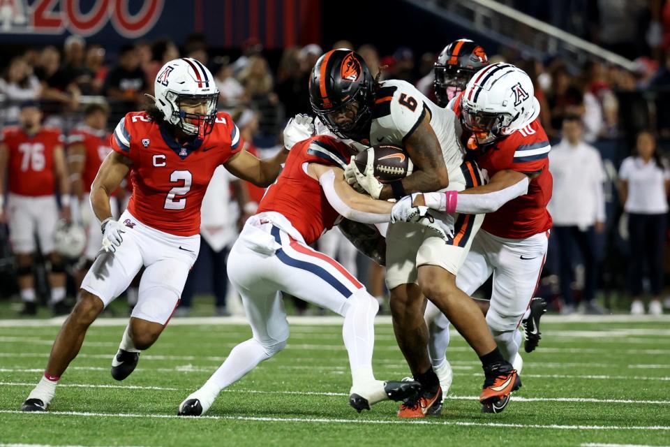 Oregon State running back Damien Martinez (6) gets swarmed by Arizona defenders during a 27-24 loss at Arizona Stadium.