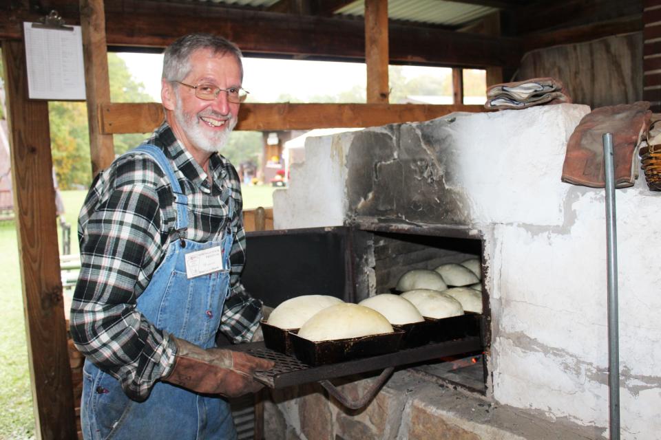 Bernard Orendorf gets the oven hot for the unbaked loaves of bread during last year's Springs Folk Festival.