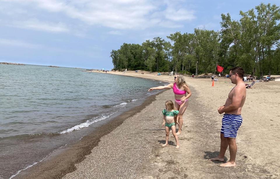Cora Stofan, 4, of Pittsburgh, tosses stones into Lake Erie on Wednesday while visiting Presque Isle State Park's Beach 8 with her mom, Amanda, and her father, Eric. No swimming was permitted at Beach 8 and three other park beaches due to 30-day levels of E. coli bacteria.
