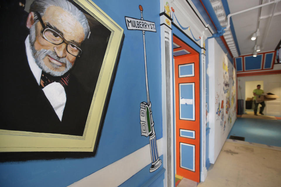 FILE — A mural that features Theodor Seuss Geisel, left, also known by his pen name Dr. Seuss, covers part of a wall May 4, 2017, near an entrance at The Amazing World of Dr. Seuss Museum, in Springfield, Mass. Seuss Enterprises, the company that owns the Dr. Seuss intellectual property, is releasing a sequel to the iconic children's book "How the Grinch Stole Christmas!" The new book is to be called "How the Grinch Lost Christmas!" (AP Photo/Steven Senne, File)