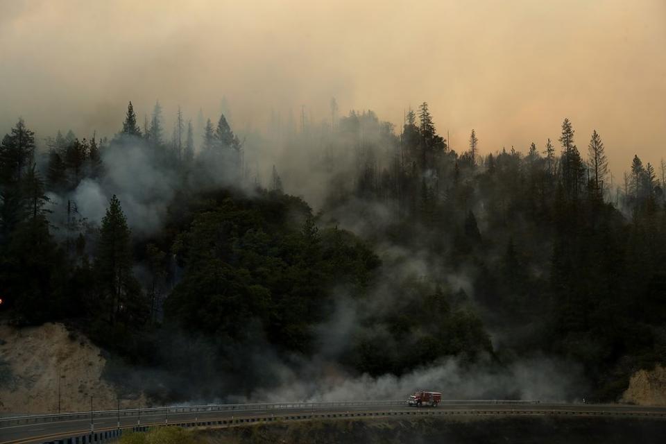 A Cal Fire truck drives along highway 299 as the Carr Fire burns in the hills near Whiskeytown, Calif. on July 28.