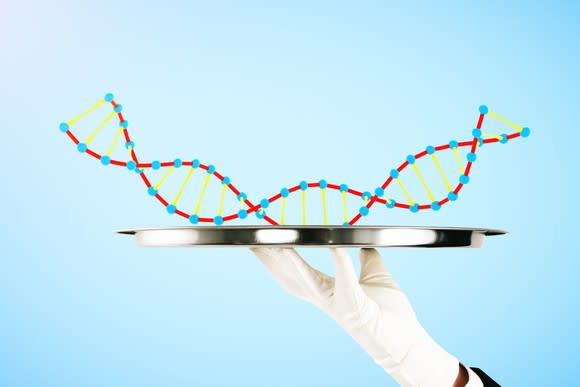 A cartoon piece of DNA being held on a silver platter by a white-gloved hand