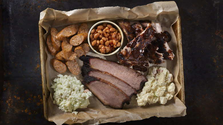 Barbecued meats and sides on a butcher paper-lined metal tray