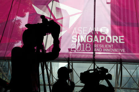 Journalists work next to the ASEAN Summit signage at Suntec Convention Centre in Singapore, November 12, 2018. REUTERS/Athit Perawongmetha