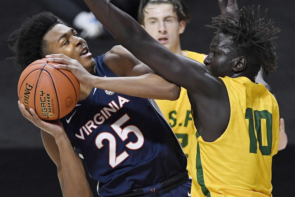 Virginia's Trey Murphy III, left, is fouled by San Francisco's Josh Kunen in the first half of an NCAA college basketball game, Friday, Nov. 27, 2020, in Uncasville, Conn. (AP Photo/Jessica Hill)