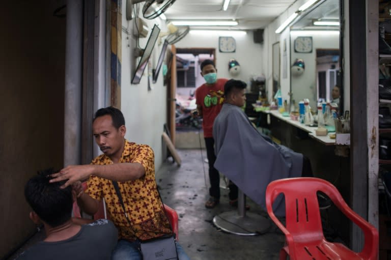 Barbers are seen working at a shop in Kampung Baru, Kuala Lumpur