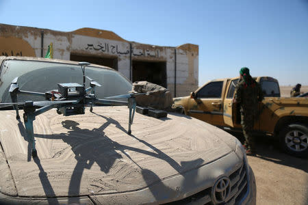 A drone is pictured as a Syrian Democratic Forces (SDF) fighter gets into a military vehicle in northern Deir al-Zor province ahead of an offensive against Islamic State militants, Syria February 21, 2017. REUTERS/Rodi Said