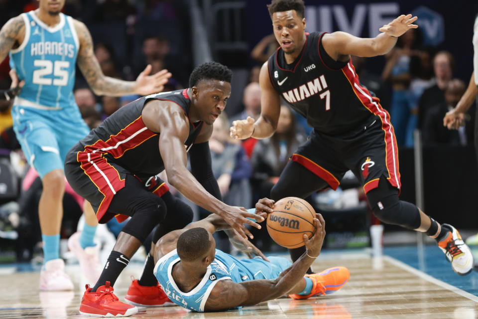 Miami Heat guards Victor Oladipo, left, and Kyle Lowry (7) battle Charlotte Hornets guard Terry Rozier for a loose ball during the second half of an NBA basketball game in Charlotte, N.C., Sunday, Jan. 29, 2023. Charlotte won 122-117. (AP Photo/Nell Redmond)