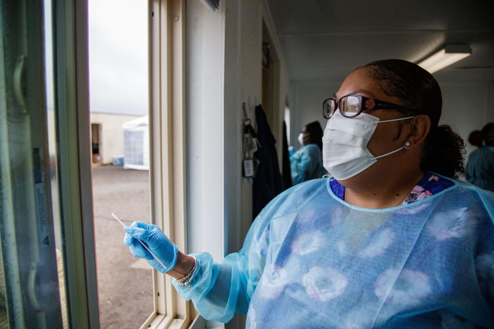 Nurse Vallie Jackson removes a swab from a patient's nose as she tests for COVID-19 at the FAMU vaccine and testing site Wednesday, Dec. 29, 2021.