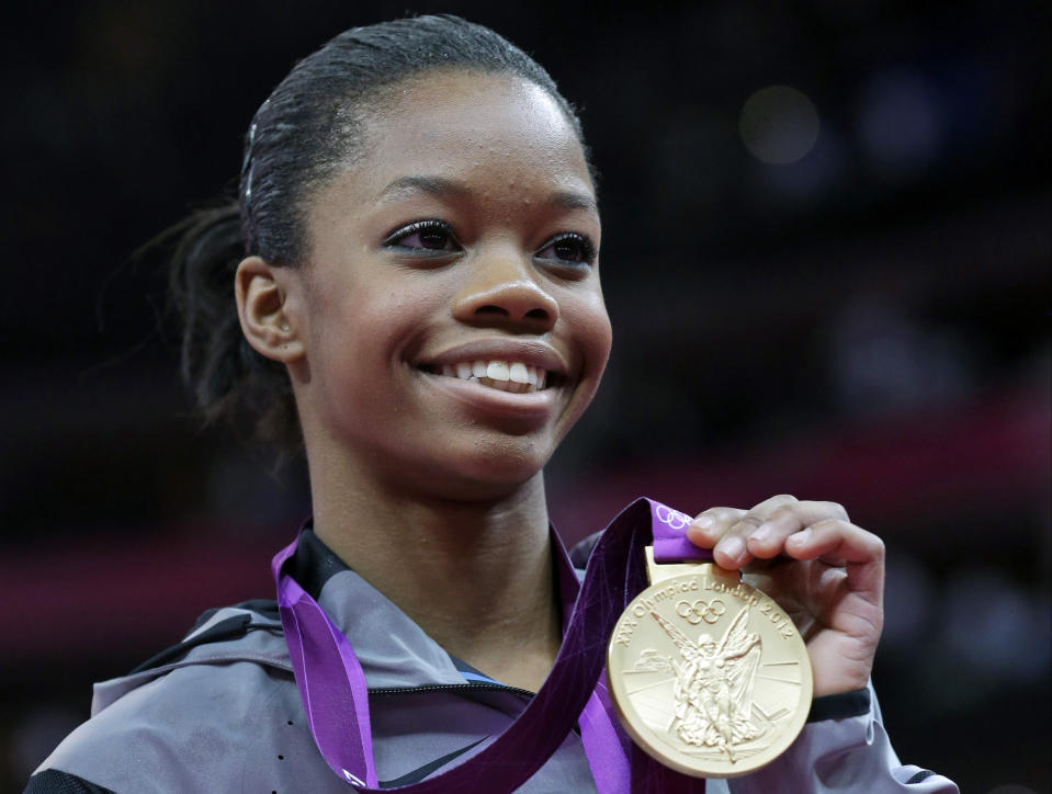 FILE - U.S. gymnast Gabby Douglas displays her gold medal during the artistic gymnastics women's individual all-around competition at the 2012 Summer Olympics in London, Aug. 2, 2012. Douglas, the first Black woman to win the Olympic all-around gymnastics title, is taking aim at the 2024 Games in Paris. Douglas announced on her Instagram page Thursday, July 13, 2023, that she is making a comeback attempt, a dozen years after her triumph in London in 2012 and eight years after her last competition, the 2016 Olympics in Rio de Janeiro. (AP Photo/Julie Jacobson, File)