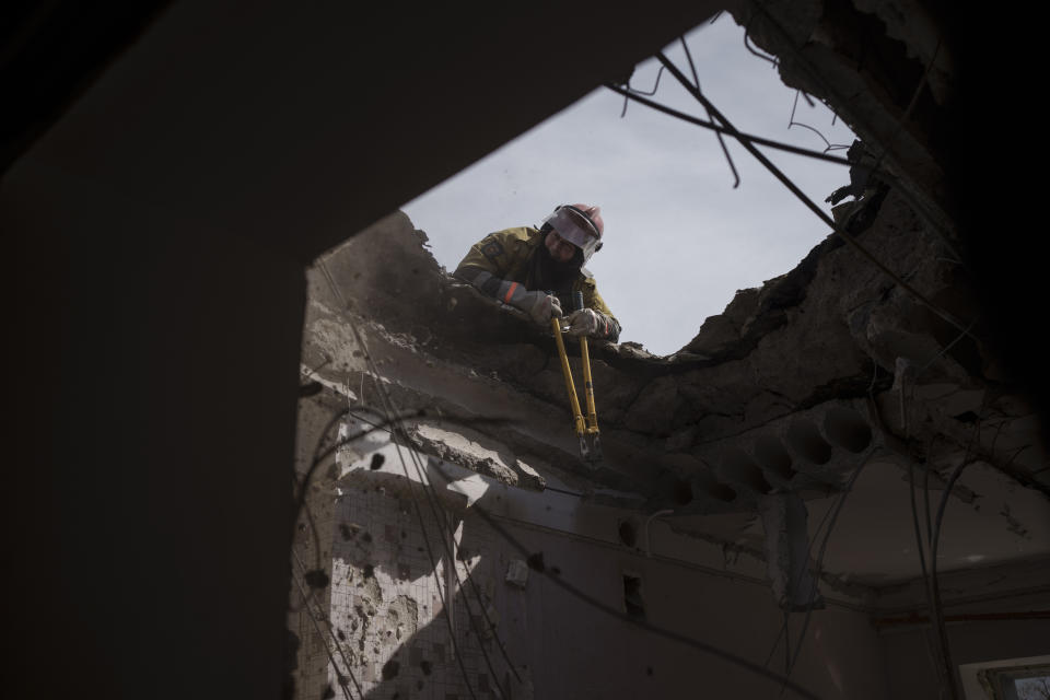 Firefighters work to secure a residential building previously damaged by a Russian attack in Kharkiv, Ukraine, Saturday, April 9, 2022. (AP Photo/Felipe Dana)