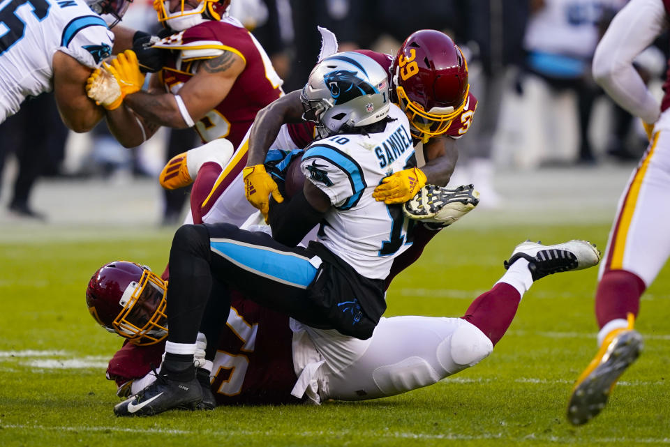 Carolina Panthers wide receiver Curtis Samuel (10) is stopped by Washington Football Team defensive tackle Tim Settle (97) and Washington Football Team defensive back Jeremy Reaves (39) during the first half of an NFL football game, Sunday, Dec. 27, 2020, in Landover, Md. (AP Photo/Susan Walsh)