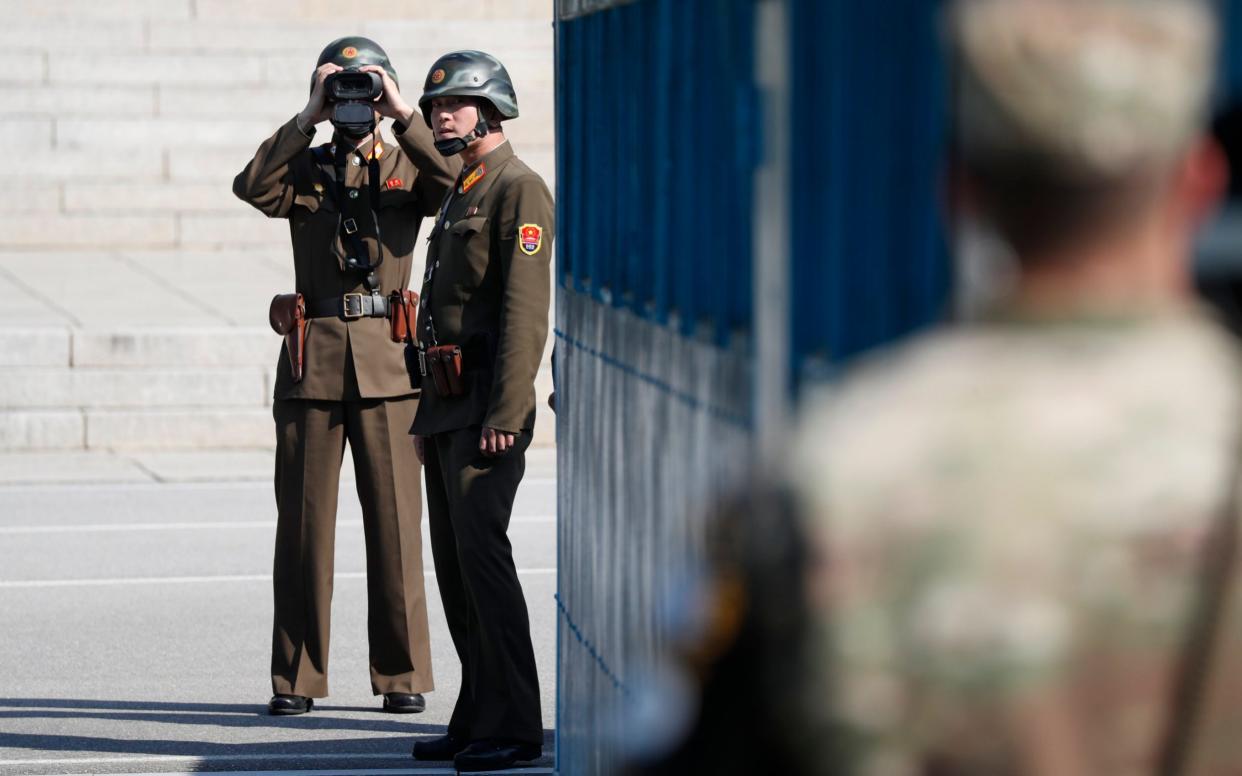 A North Korean soldier looks through binoculars toward South Korea  - EPA POOL