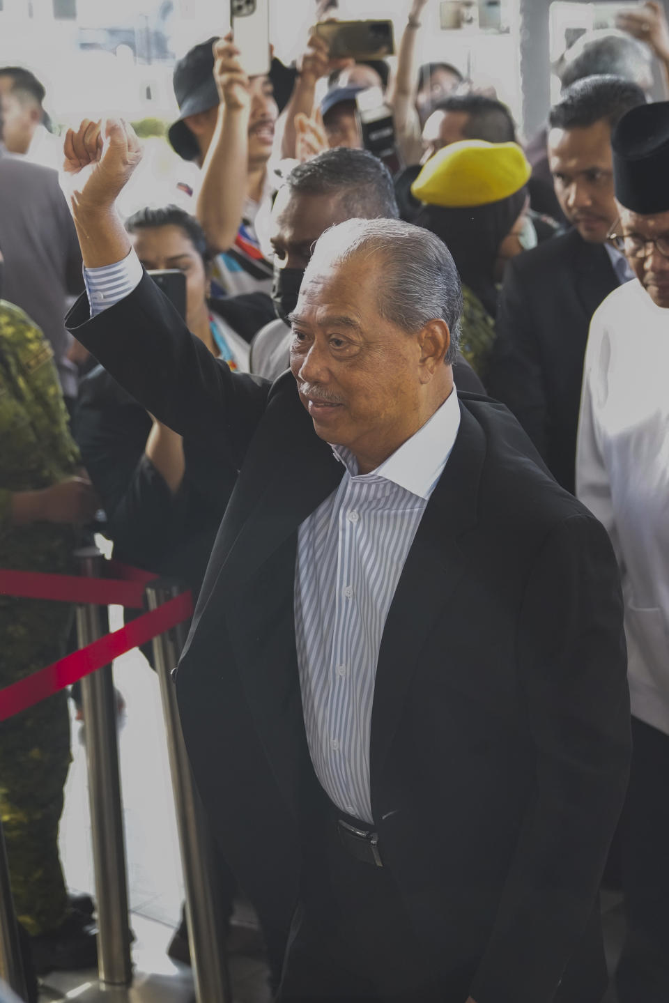 Malaysia's former Prime Minister Muhyiddin Yassin waves as he arrives at courthouse for a corruption charges in Kuala Lumpur, Malaysia, Friday, March 10, 2023. Muhyiddin, who led Malaysia from March 2020 until August 2021, will be the country's second leader to be indicted after leaving office. (AP Photo/Vincent Thian)