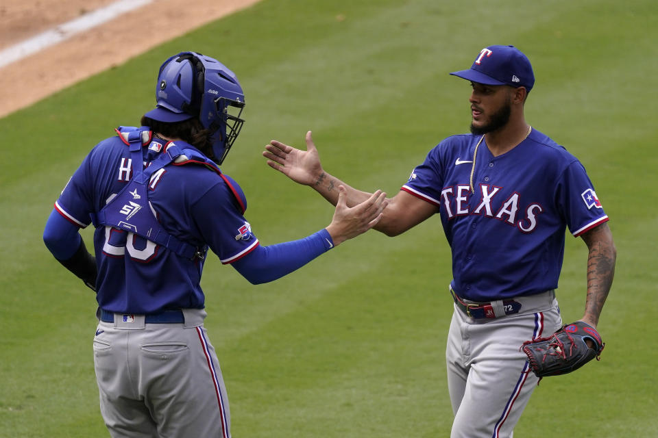 Texas Rangers catcher Jonah Heim, left, and relief pitcher Jonathan Hernandez congratulate each other after the Rangers defeated the Los Angeles Angels 5-2 in a baseball game Sunday, July 31, 2022, in Anaheim, Calif. (AP Photo/Mark J. Terrill)