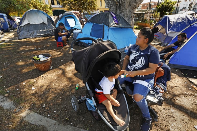 Los Angeles, California-Oct. 2, 2021-A major clean up of MacArthur Park is schedule for October 15, 2021 to move out the homeless encampment that has taken hold there. The encampment in MacArthur Park on Saturday, Oct. 2, 2021. A woman and child who arrived five-months ago from Honduras are now living in a homeless shelter, but come back to visit friends. (Carolyn Cole / Los Angeles Times)