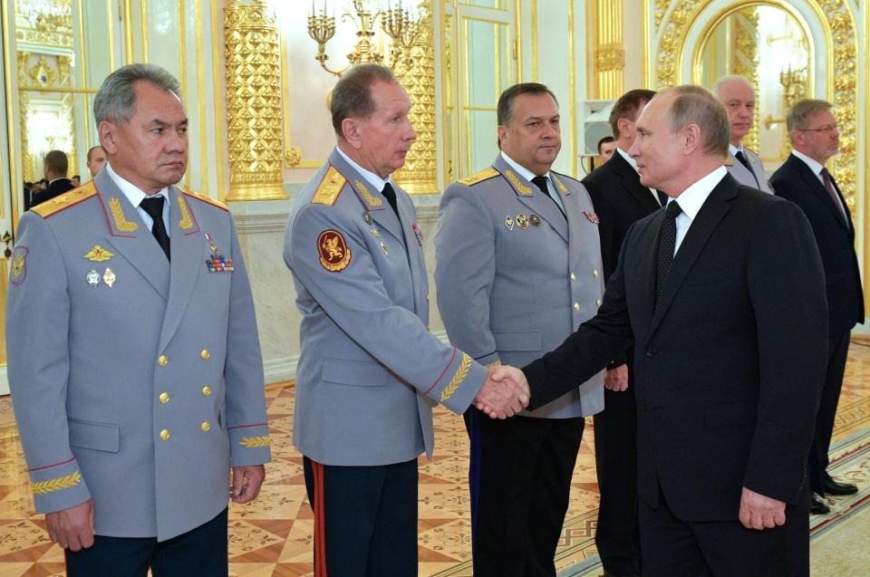 Russian President Vladimir Putin, right, greets Commander-in-Chief of the National Guard troops Viktor Zolotov, second left, Defense Minister Sergei Shoigu, left, and Director of the Federal Security Service Dmitry Kochnev, right, during a meeting with top military officers and law enforcement officials in the Kremlin in Moscow, Russia, Thursday, Oct. 25, 2018. Putin said that Russia has adhered to its obligations in the arms control sphere, but noted that Russian arsenals will be modernized to ensure protection from any potential threats. (Alexei Nikolsky, Sputnik, Kremlin Pool Photo via AP)