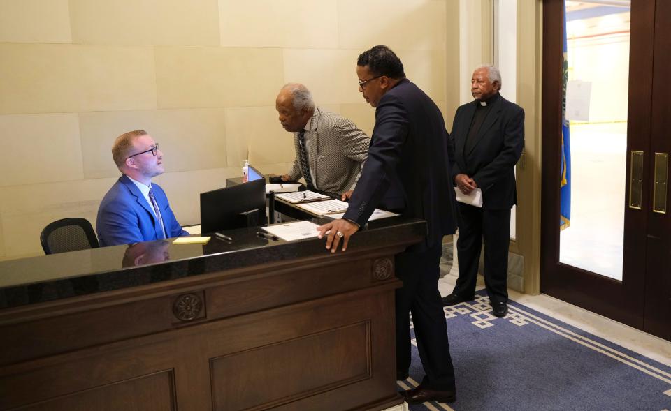 A receptionist in Gov. Kevin Stitt's office talks to the Rev. John A. Reed, left, and Rev. Derrick Scobey on Tuesday as the Rev.  Marvin L. Morgan of Charlottesville, Virginia, waits.