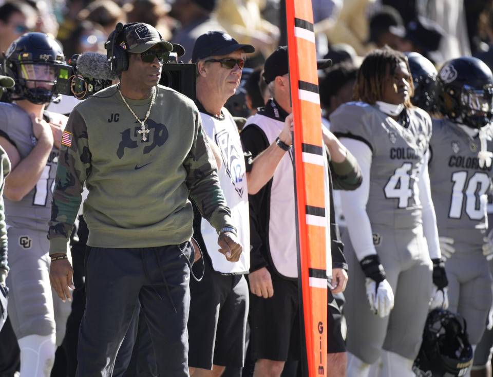 Colorado head coach Deion Sanders, left, looks on in the first half of an NCAA college football game against Arizona on Saturday, Nov. 11, 2023, in Boulder, Colo. (AP Photo/David Zalubowski)