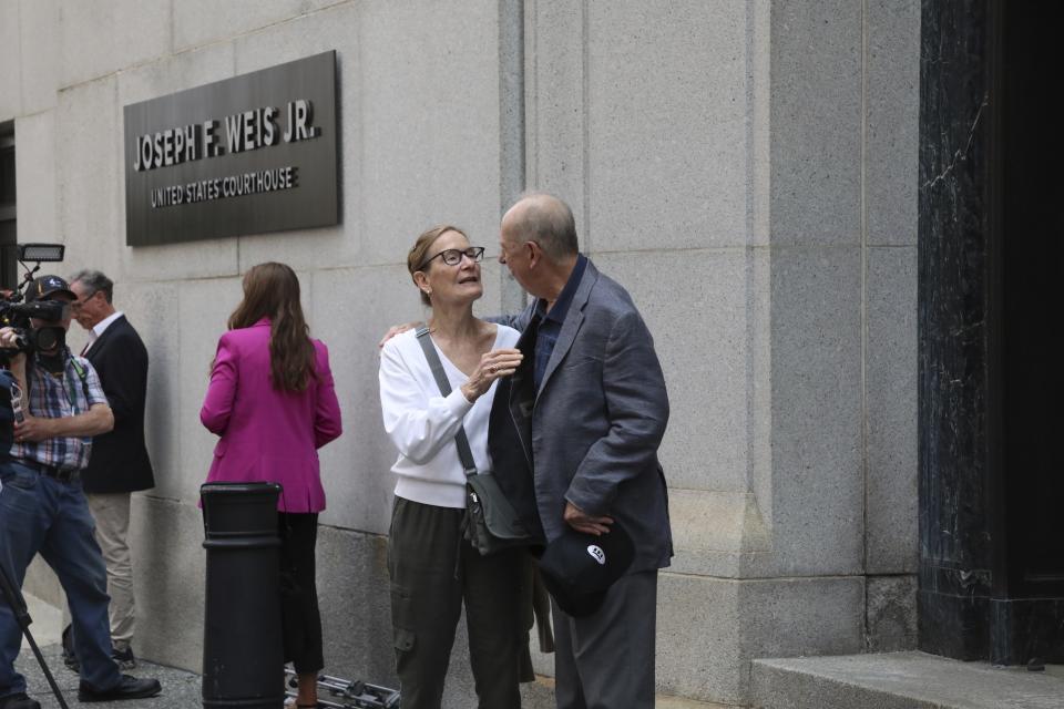 Jean Clickner hugs another man following the sentencing of Robert Bowers outside the Joseph F. Weis Jr. United States Courthouse in Pittsburgh, Wednesday, Aug 2, 2023. Bowers was sentenced to death for killing 11 people at the Tree of Life synagogue in Pittsburgh in 2018. (AP Photo/Rebecca Droke)