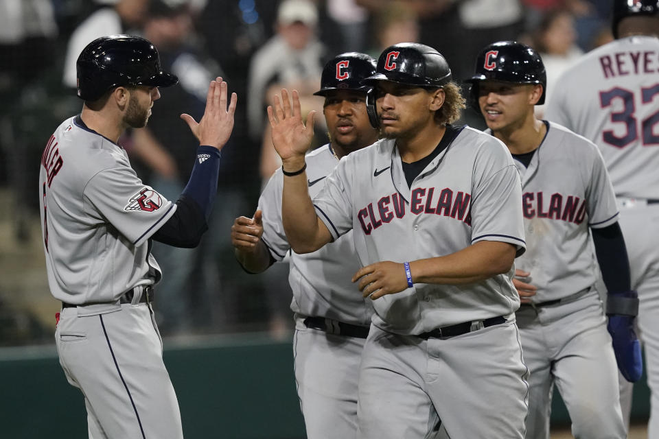 Cleveland Guardians' Josh Naylor, center, celebrates his game tying grand slam off Chicago White Sox relief pitcher Liam Hendriks during the ninth inning of a baseball game Monday, May 9, 2022, in Chicago. (AP Photo/Charles Rex Arbogast)