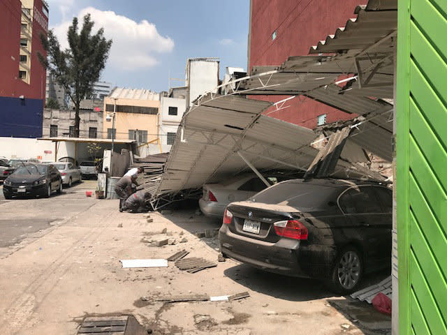 An awning collapsed onto parked cars.&nbsp;