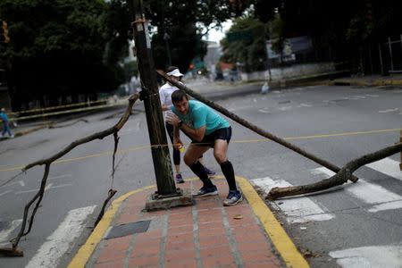 Runners pass through a blocked street during a strike called to protest against Venezuelan President Nicolas Maduro's government in Caracas, Venezuela July 26, 2017. REUTERS/Ueslei Marcelino
