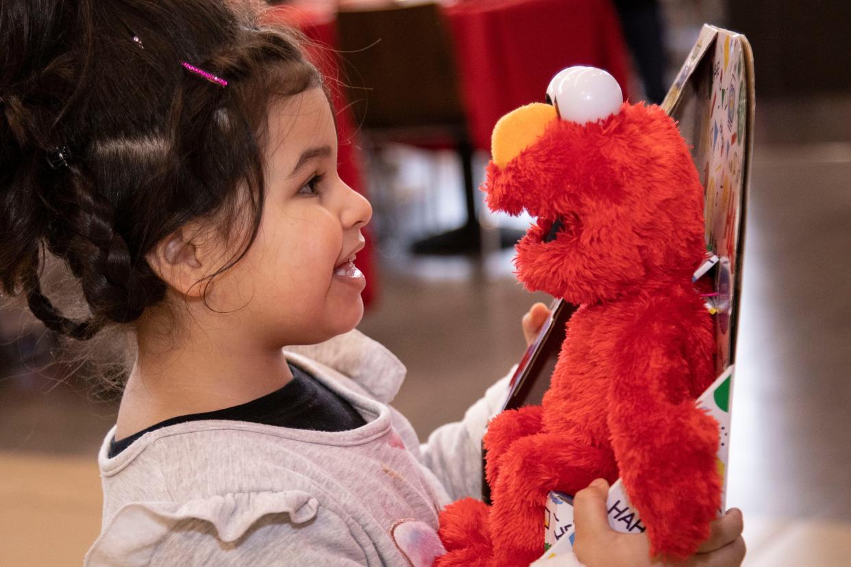 A child holds a gift at Sunday's Christmas Feast, hosted by Boca Helping Hands and The Town Center of Boca Raton.