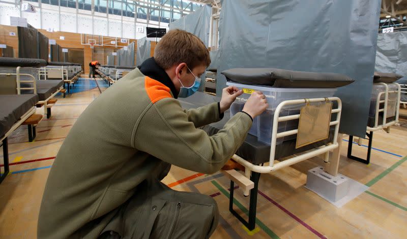 A civil defence worker places a sticker on a bed of the Medical Center Luzern which can offer some 220 additional beds for patients of the coronavirus disease (COVID-19) in Nottwil