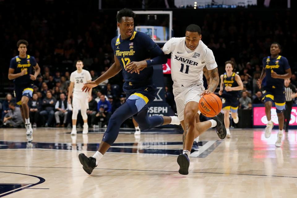 Xavier Musketeers guard Dwon Odom (11) drives to the basket against Marquette Golden Eagles forward Olivier-Maxence Prosper (12) in the first half of the NCAA Big East Conference game between the Xavier Musketeers and the Marquette Golden Eagles at the Cintas Center in Cincinnati on Saturday, Dec. 18, 2021. Xavier led 38-36 at halftime. 