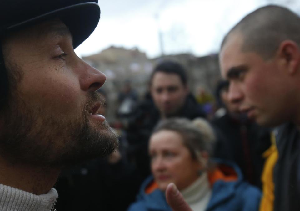 In this photo taken Wednesday, March 5, 2014, local residents discuss the situation at a central square in Simferopol, Ukraine. Ukraine is facing a potentially crippling geographic and cultural divide, a growing gulf between supporters of Russia who dominate the east and south of the country, and western Ukrainians who yearn for closer ties to Western Europe. One side of that divide is even starker in Crimea, a Black Sea peninsula. For much of the past 200 years, Crimea was under Russian and Soviet control, and today most Crimeans see themselves as only nominally Ukrainian and Russian is, by far, the dominant language (AP Photo/Sergei Grits)