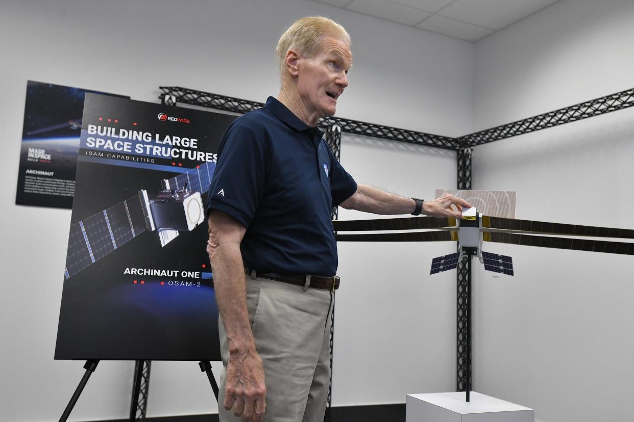 NASA Administrator Bill Nelson explains uses of space technology with a model of Redwire's Archinaut self-constructing satellite concept during a May 10 tour of the Jacksonville headquarters. The private equity owned company is involved in developing satellites that can build themselves after launch using robotic 3D printer technology as well as designing an orbiting platform that micro experiment modules can be attached to.