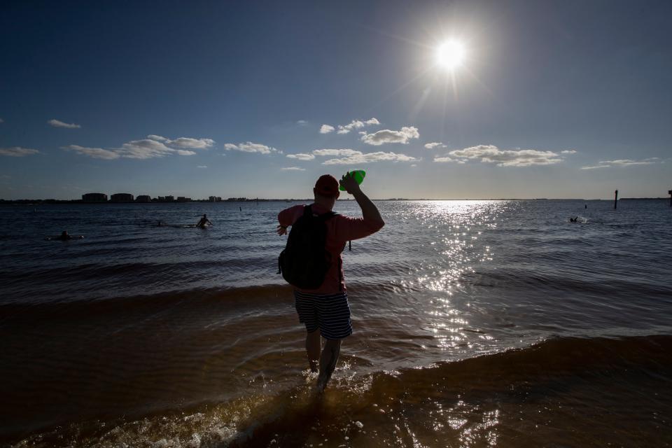 Eric Babiarz, visiting from Buffalo, NY, plays football with his sons along the shores of the Caloosahatchee River while visiting the Cape Coral Yacht Club Wednesday, November 24, 2021. 