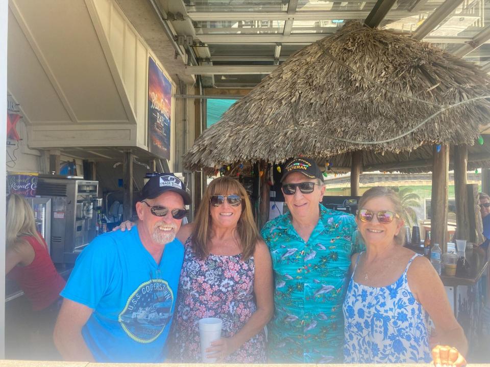 Navy veteran Ty Beach, LEFT, stands alongside wife and Air Force veteran Susan Beach, Air Force veteran Wayne Walker and Marianne Walker at the Sandshaker bar Thursday afternoon to watch the Blue Angels practice show.
