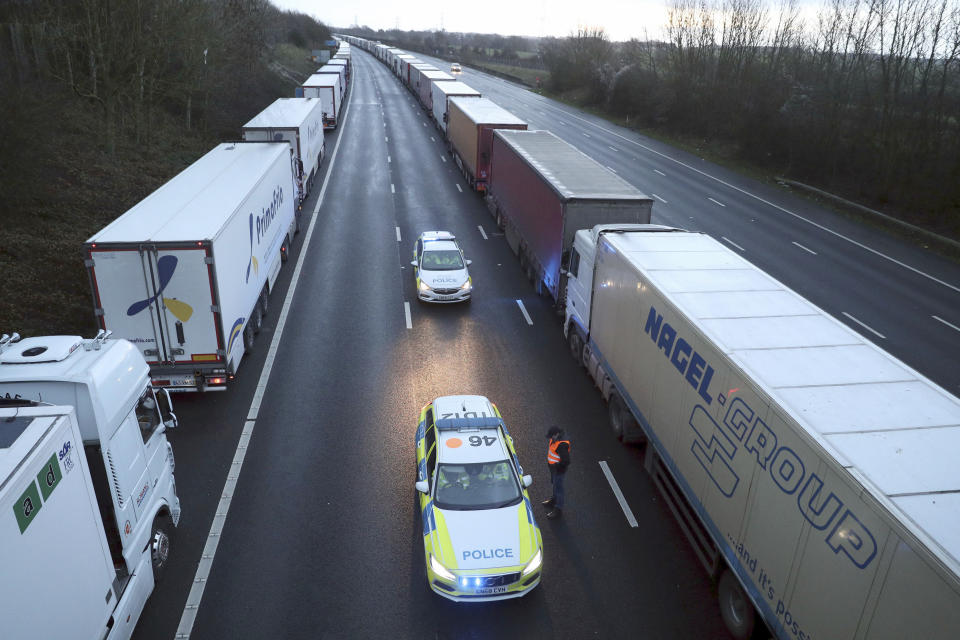 Police patrol along the M20 motorway where freight traffic is halted whilst the Port of Dover remains closed, in Ashford, Kent, England, Tuesday, Dec. 22, 2020. Trucks waiting to get out of Britain backed up for miles and people were left stranded at airports as dozens of countries around the world slapped tough travel restrictions on the U.K. because of a new and seemingly more contagious strain of the coronavirus in England. (Andrew Matthews/PA via AP)