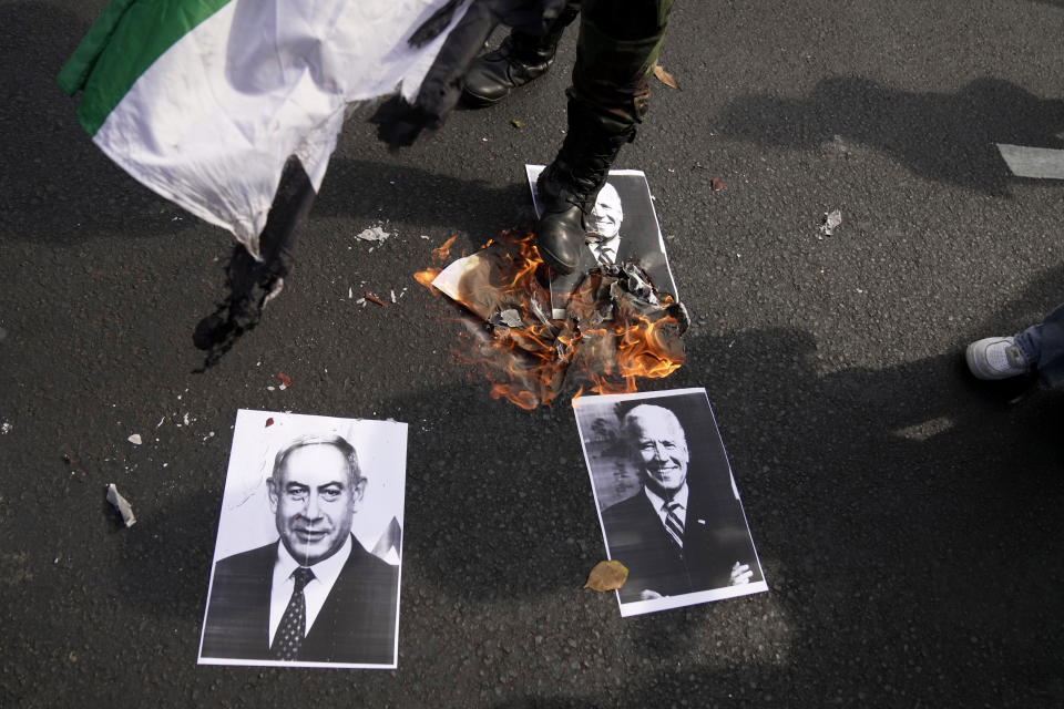 A protester steps on a burning portrait of U.S. President Joe Biden and Israeli Prime Minister Benjamin Netanyahu during a rally supporting the Palestinian people outside the U.S. Embassy in Jakarta, Indonesia, Friday, Oct. 20, 2023. Hundreds of people staged protests in Indonesia's capital Friday to denounce the staunch American support for Israel and demand an end to Israeli airstrikes on the Gaza Strip. (AP Photo/Dita Alangkara)